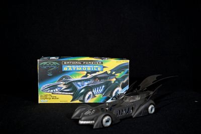 a batman batmobile toy next to a box of batmobiles