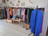 a photo of a clothing store with clothes on racks