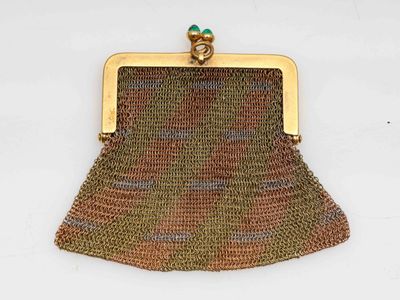 un vieux sac à main avec un fermoir doré sur fond blanc