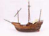 a wooden model of a boat on a white surface