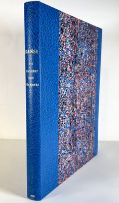 a blue book sitting on top of a white table next to a white wall