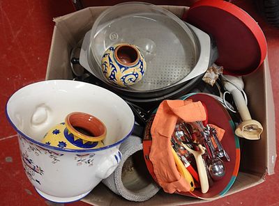 une boîte remplie d'ustensiles de cuisine posée par terre