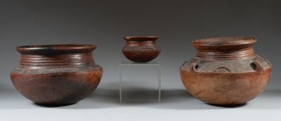 three brown vases sitting on top of a table next to each other