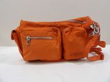 un gros plan d'un sac à main orange posé sur une surface blanche