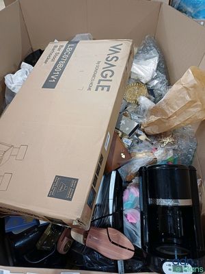 une boîte en carton remplie d'objets hétéroclites sur le sol