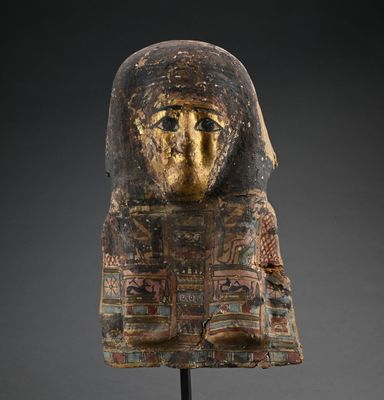 un masque égyptien antique peint en doré sur fond noir