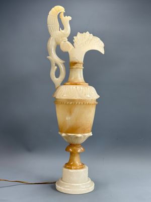 une image représentant un vase blanc surmonté d'un oiseau