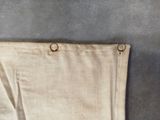 a piece of cloth hanging on the wall next to a pair of scissors