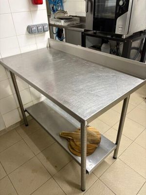une table en acier inoxydable dans une cuisine équipée d'un micro-ondes