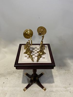 pair of antique brass candlesticks on a chess board