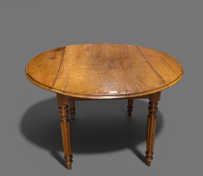 une table à manger ovale en chêne, avec des pieds et un plateau tournés