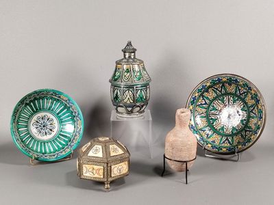 Plusieurs pièces de poterie sont exposées sur un support gris.