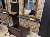 two chairs in a salon with mirrors on the wall