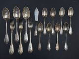a lot of silver spoons and forks on a black table