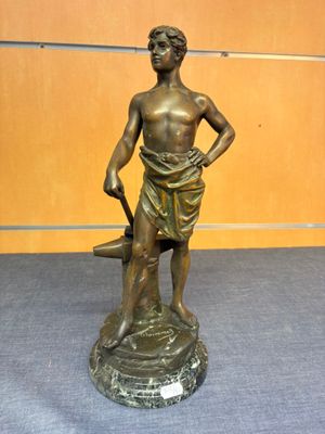 bronze statue of a boy with an umbrella standing on a rock
