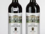 deux bouteilles de vin posées l'une à côté de l'autre sur une surface blanche