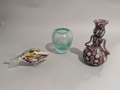 un vase en verre et un poisson en verre placés l'un à côté de l'autre