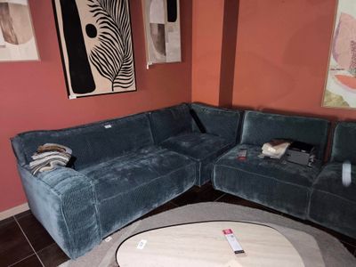 un grand canapé bleu dans un coin du salon