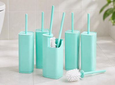 quatre brosses à dents et un porte-brosses à dents posés sur le plan de toilette de la salle de bains