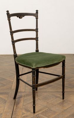 une chaise en bois avec une assise verte posée sur un parquet