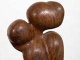 wooden sculpture of a mother and child on a pedestal against a white background