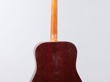 an acoustic guitar hanging from a wall