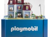 Le Playmobil se trouve dans une vitrine avec une maison de poupées