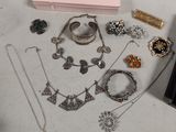 a lot of jewelry sitting on a table next to a pink box