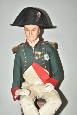 a statue of a man in a military uniform sitting on a stool