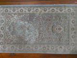 un vieux tapis posé sur un parquet dans une pièce