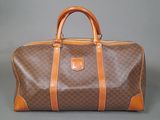 an image of a brown and tan duffel bag on a grey background