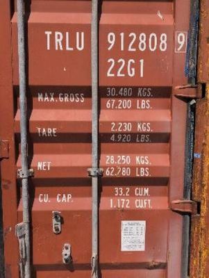a red shipping container that is sitting on the side of the road