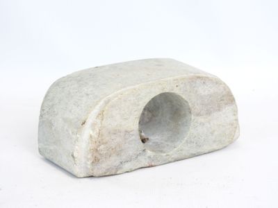 a small white rock with a hole in it