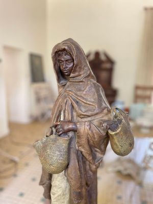 une statue représentant une femme tenant un panier dans un salon