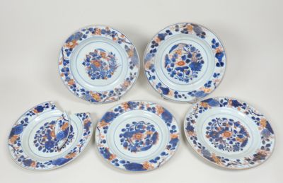six assiettes bleues et blanches ornées de fleurs orange, posées sur une table