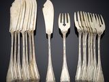 several forks and spoons are arranged in a row on a table