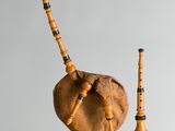deux pipes en bois et une cornemuse accrochée au mur