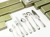 beaucoup d'argenterie dans une boîte verte posée sur une table blanche