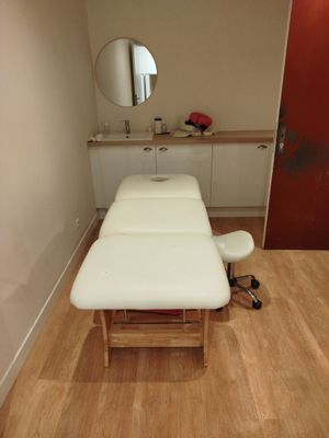 une table de massage dans une pièce où il y a un miroir accroché au mur