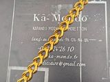 une photo d'un bracelet en or exposé devant une carte de visite