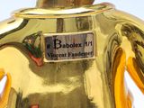 a gold colored teapot with a black and white cat on it