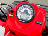 a close up of a red motorcycle with a speedometer on it