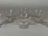 six verres à vin transparents posés sur une table blanche