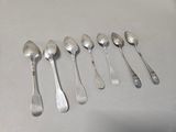 six spoons and two spoons sitting on a table
