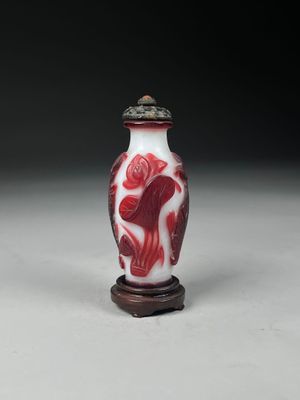 un vase rouge et blanc posé sur un socle en bois