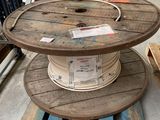 une bobine en bois posée sur une palette dans un entrepôt