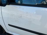 a small white car with a dog sitting in the driver ' s seat