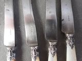 four knives and a knife holder on a table