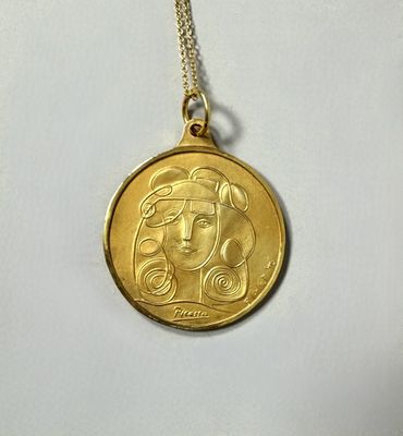 a close up of a gold coin with a woman ' s face on it