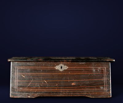 an old wooden chest with a black top and brown wood trim
